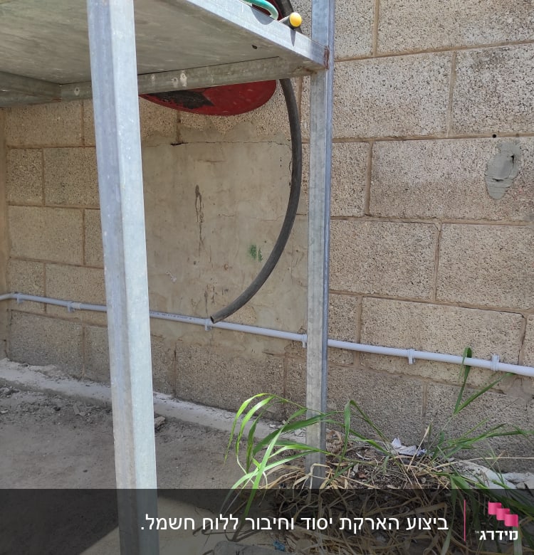 צינור חשמל מותקן על קיר בטון עם תיבת חיבורים